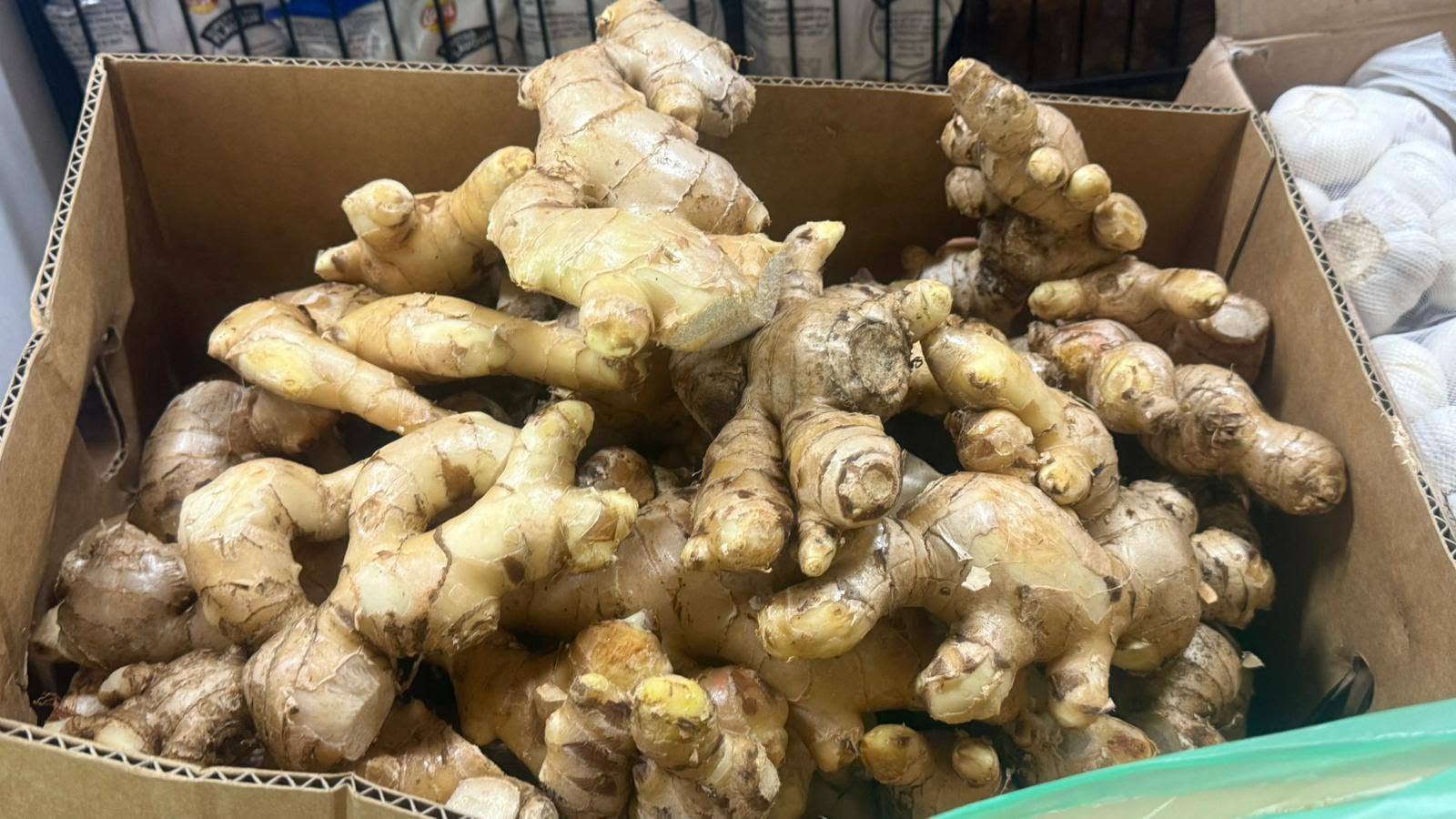 A cardboard box filled with fresh ginger root